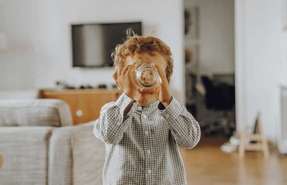 Little boy drinking full glass of water