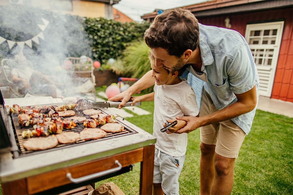 Dad barbecuing with son