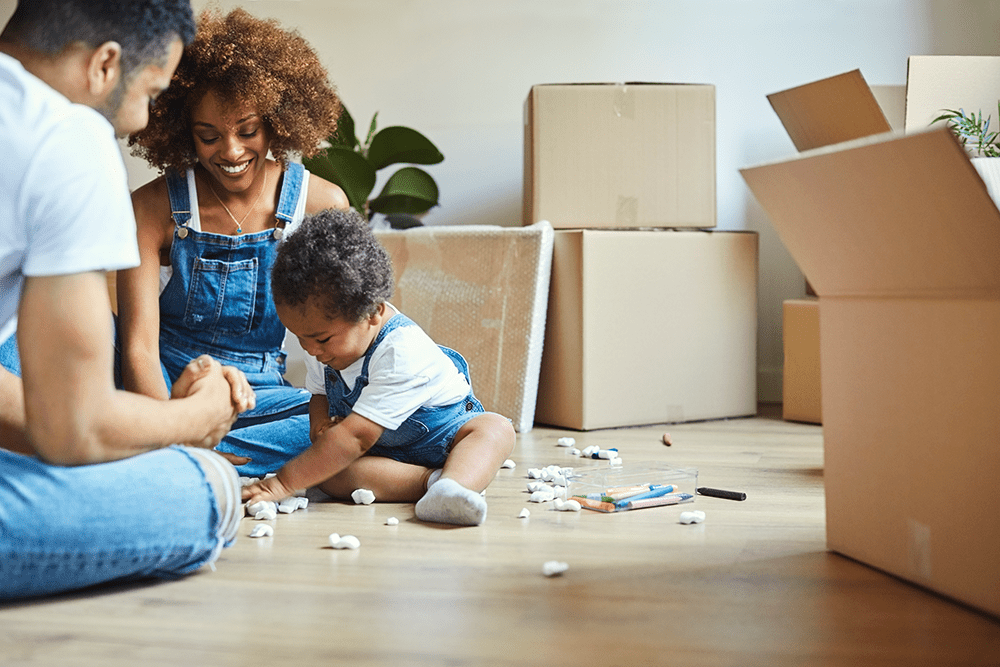 New homeowners playing with their baby on the floor