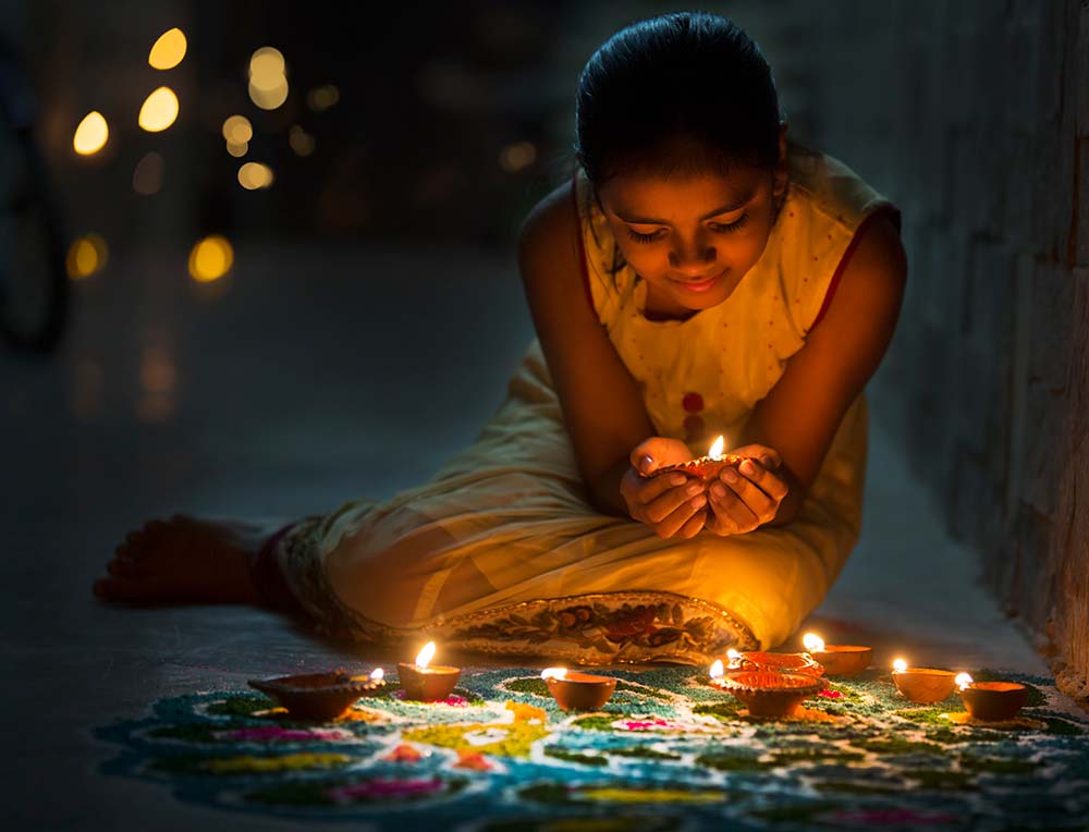 Little girl celebrating Diwali with rangoli