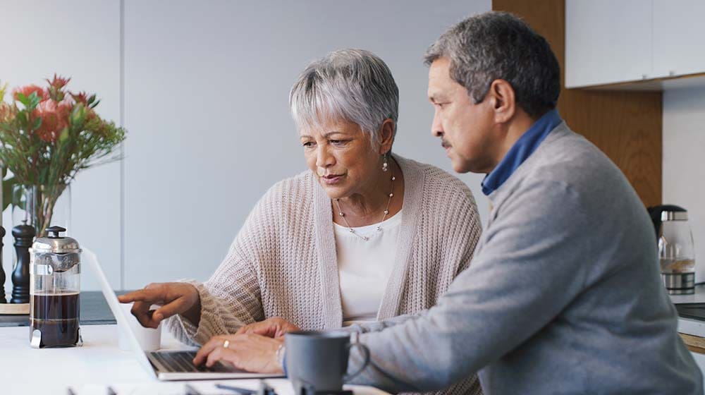 Senior couple looking at gifting a BetterLife life insurance policy on the computer
