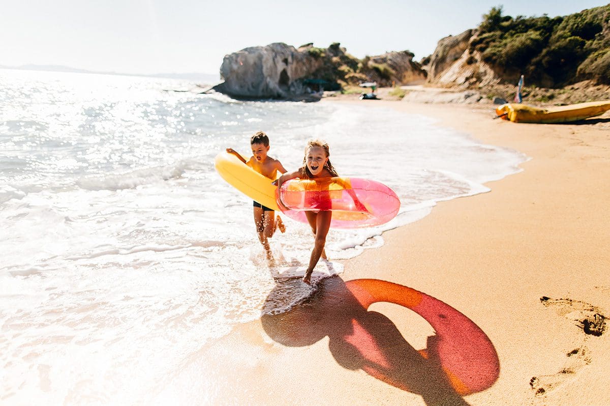 Two children running on the beach