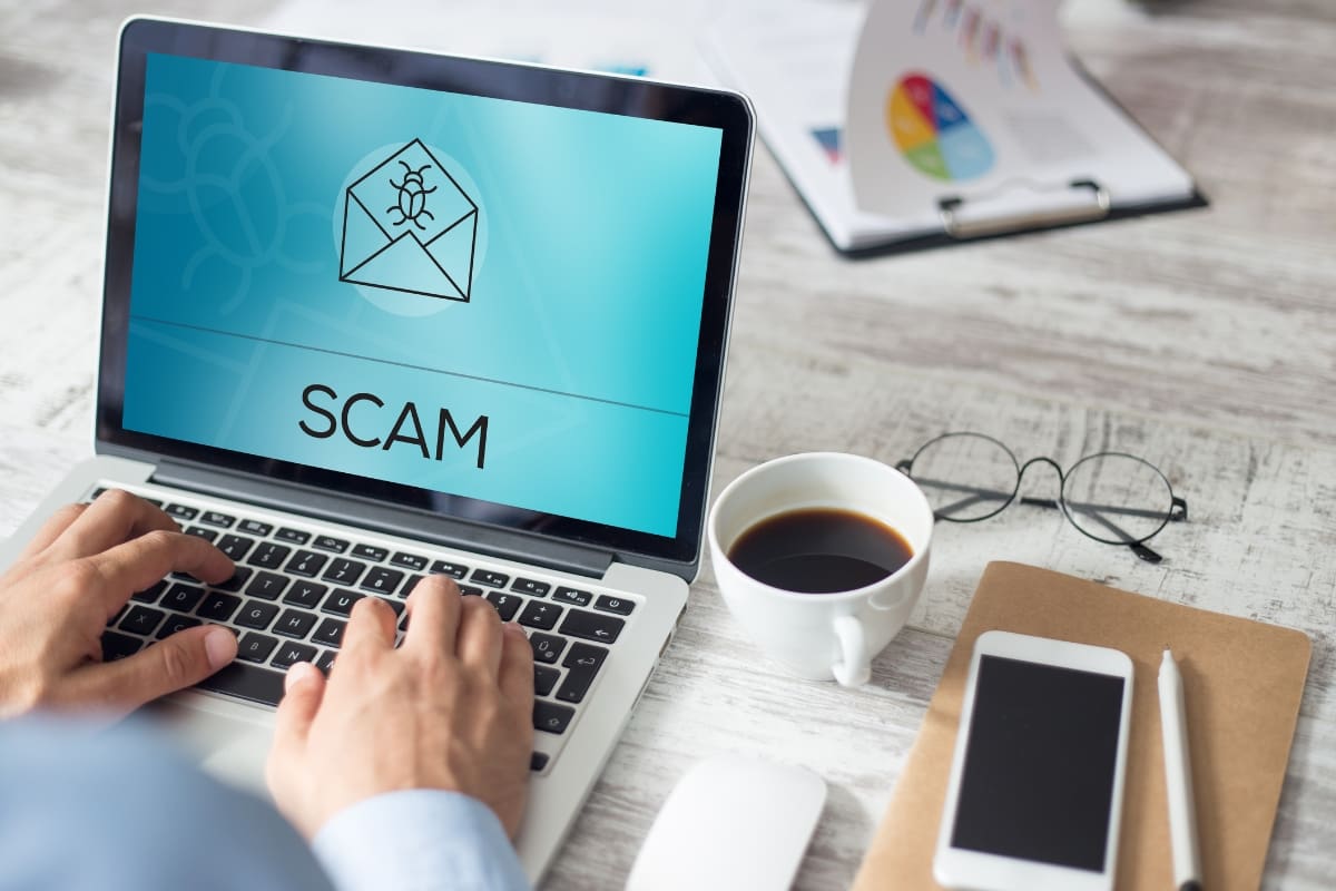 Person working at laptop and finding a phishing email