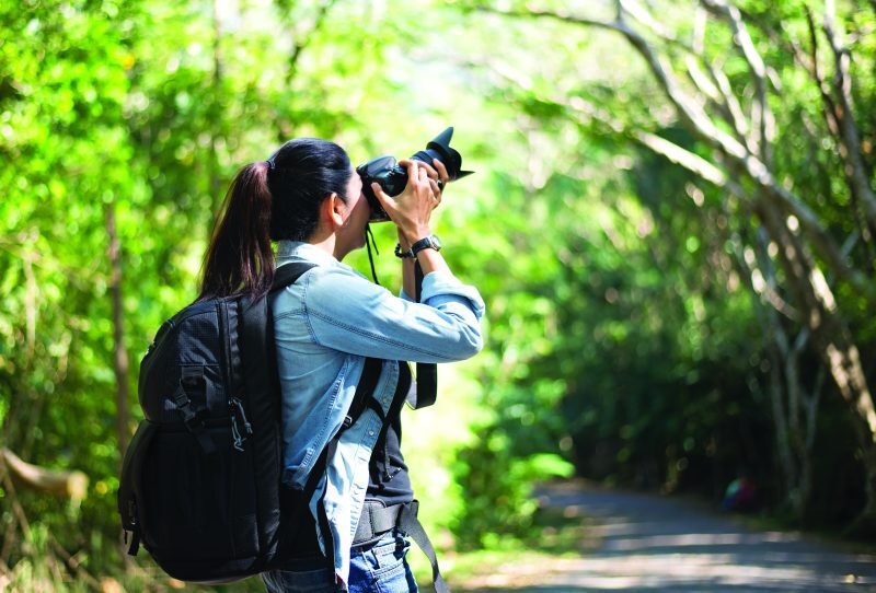 Professional woman photographer taking outdoor portraits with prime lens