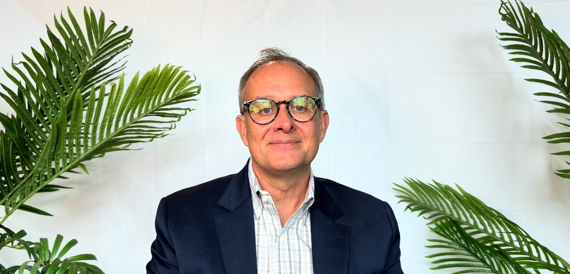 Chris Campbell in front of a background smiling at the camera.